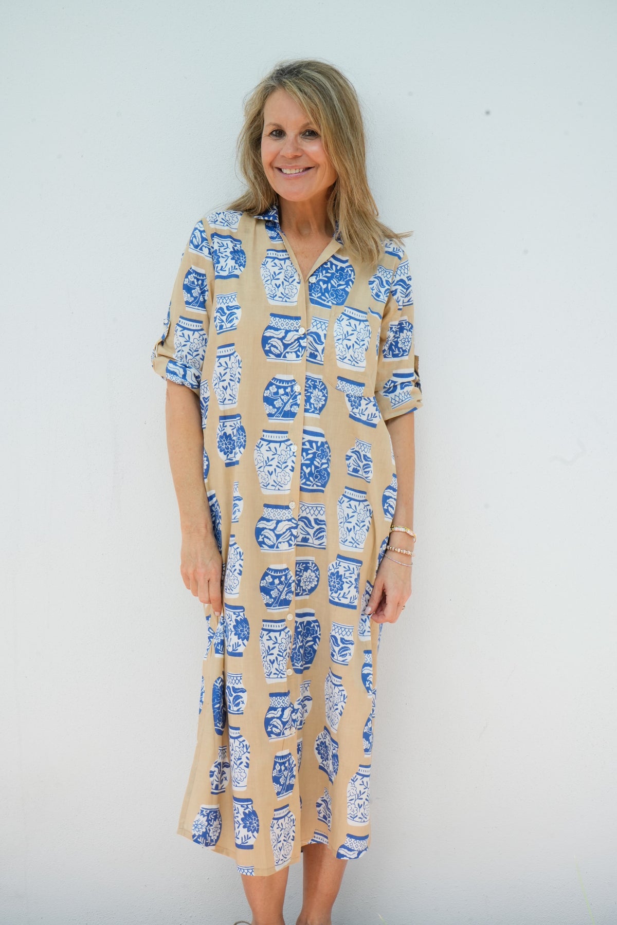 Woman wearing a patterned dress against a plain background